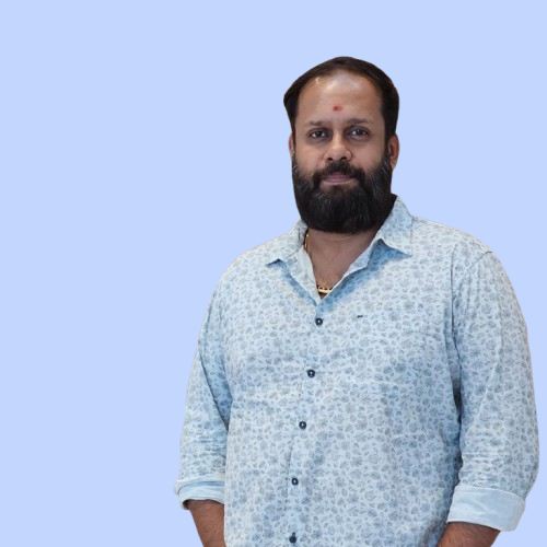 Portrait photo of Qutbuddin Habib, male with short hair, wearing a dark blazer and shirt, looking confident with folded arms