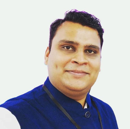 Portrait photo of Qutbuddin Habib, male with short hair, wearing a dark blazer and shirt, looking confident with folded arms